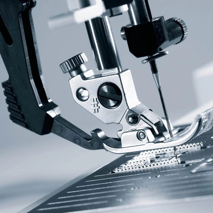 Close-up of a sewing machine needle and presser foot on a blurred background