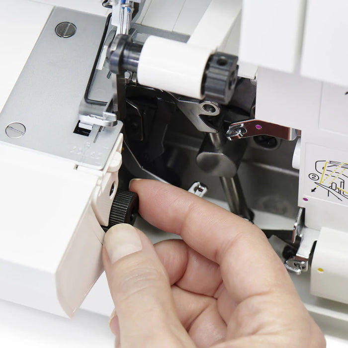 Hand adjusting differential feed control inside SINGER SE017 Elite serger for smooth seams on stretch and lightweight fabrics