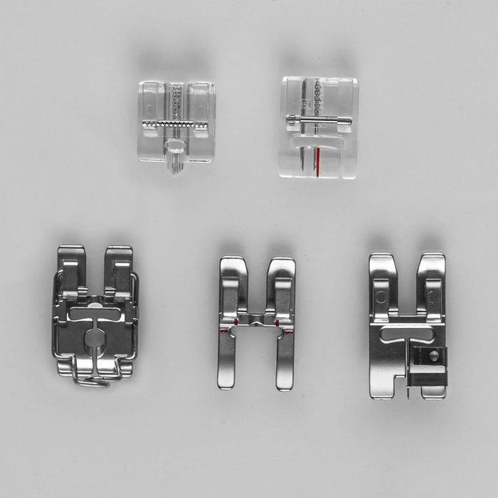 Set of five metal sewing machine presser feet on a gray background
