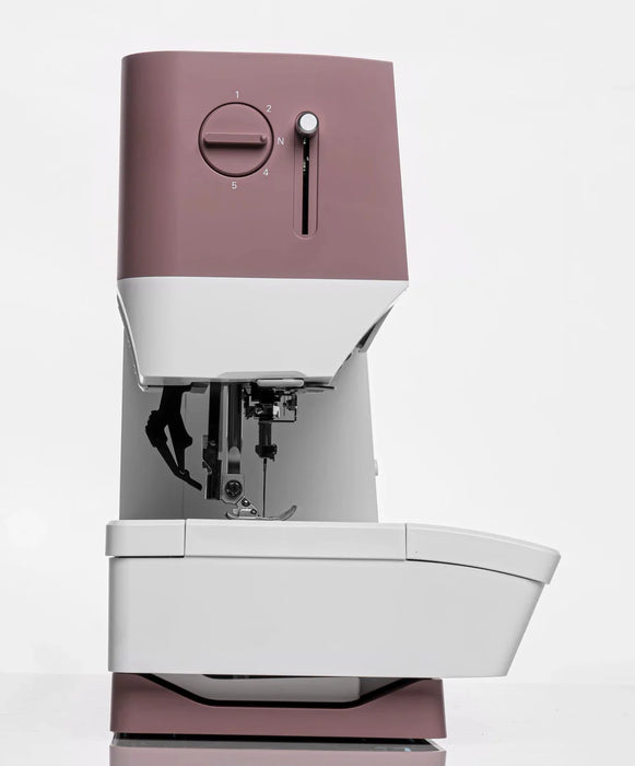 Sewing machine with a maroon top and base on a white background