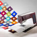 Sewing machine with colorful fabric samples on a white background