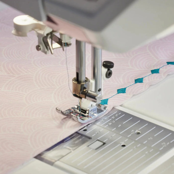 Detailed view of presser foot and needle stitching decorative quilting patterns on the Husqvarna Viking EPIC QUILT 97