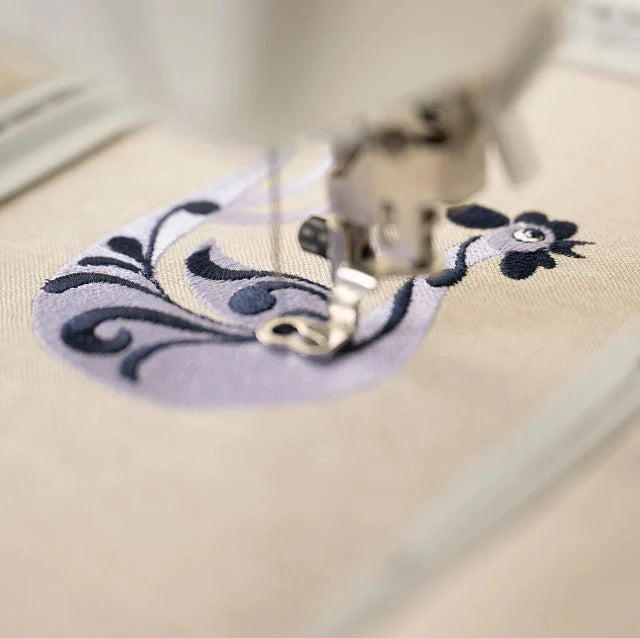 Close-up of Husqvarna Viking Designer Quartz 29 stitching an embroidery design with precision needle movement