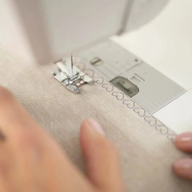 Husqvarna Viking Designer Quartz 29 sewing machine creating decorative stitches on fabric close-up