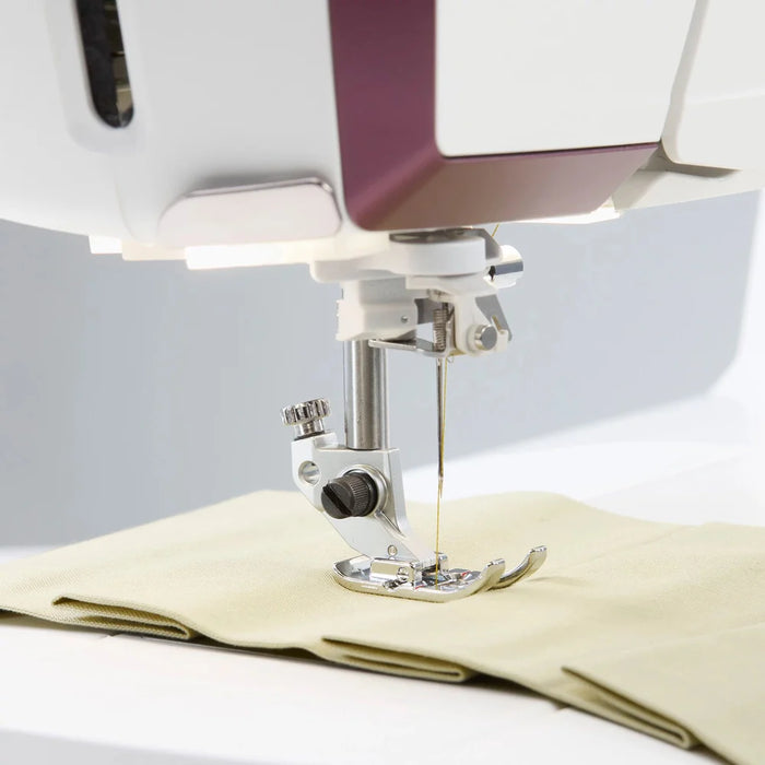 Close-up of Husqvarna Viking Designer Topaz 65 presser foot sewing lightweight fabric with precision stitching