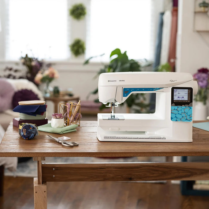 Husqvarna Viking Opal 670 computerized sewing machine displayed on a wooden table in a modern home sewing room