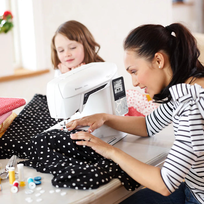 Husqvarna Viking Opal 690Q sewing machine in use at home sewing black polka dot fabric for garment creation