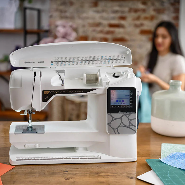 Husqvarna Viking Opal 690Q computerized sewing machine displayed on worktable with accessories and large sewing surface