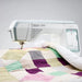 Husqvarna Viking Topaz 55Q sewing machine quilting a patchwork quilt with extended throat space and precision stitching
