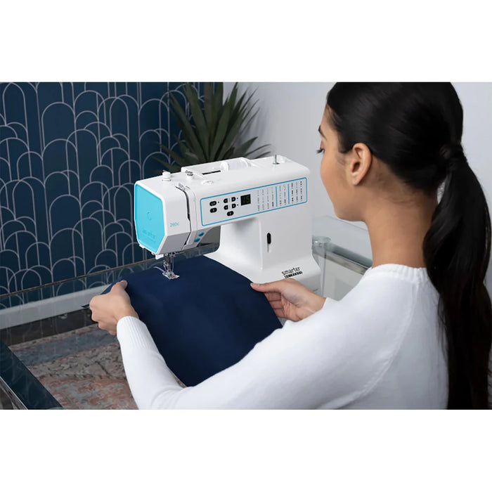Woman using a sewing machine to sew a piece of fabric.