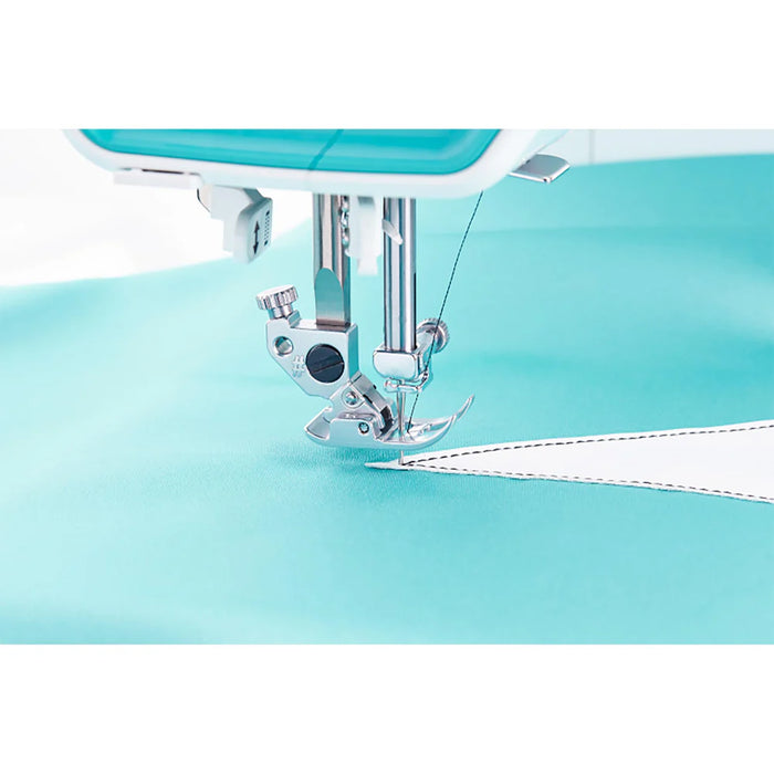 Close-up of a sewing machine needle on a light blue fabric background