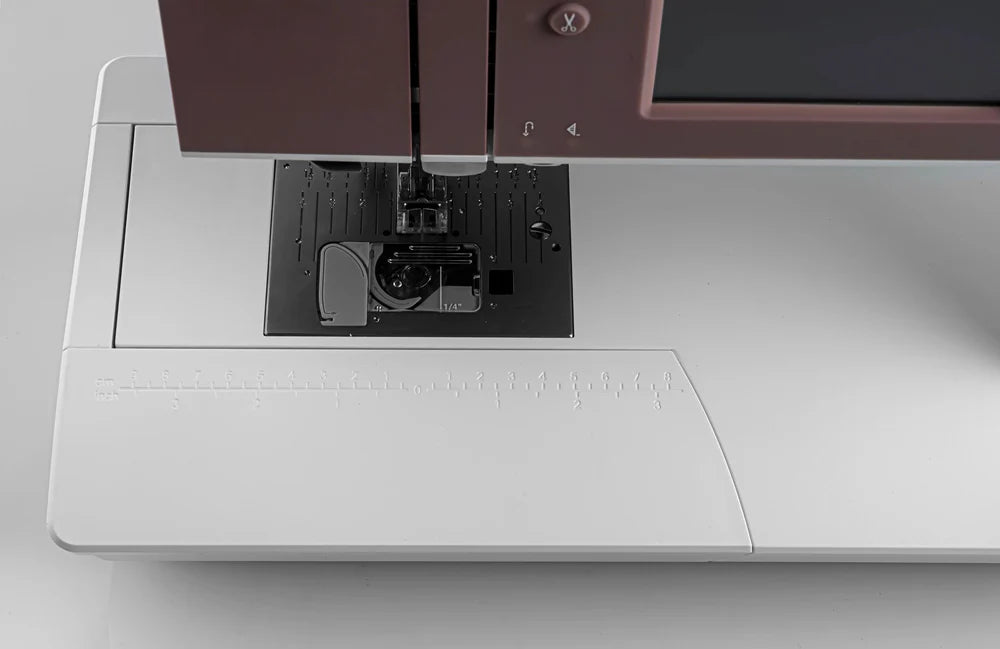 Close-up of a sewing machine needle and presser foot on a white background